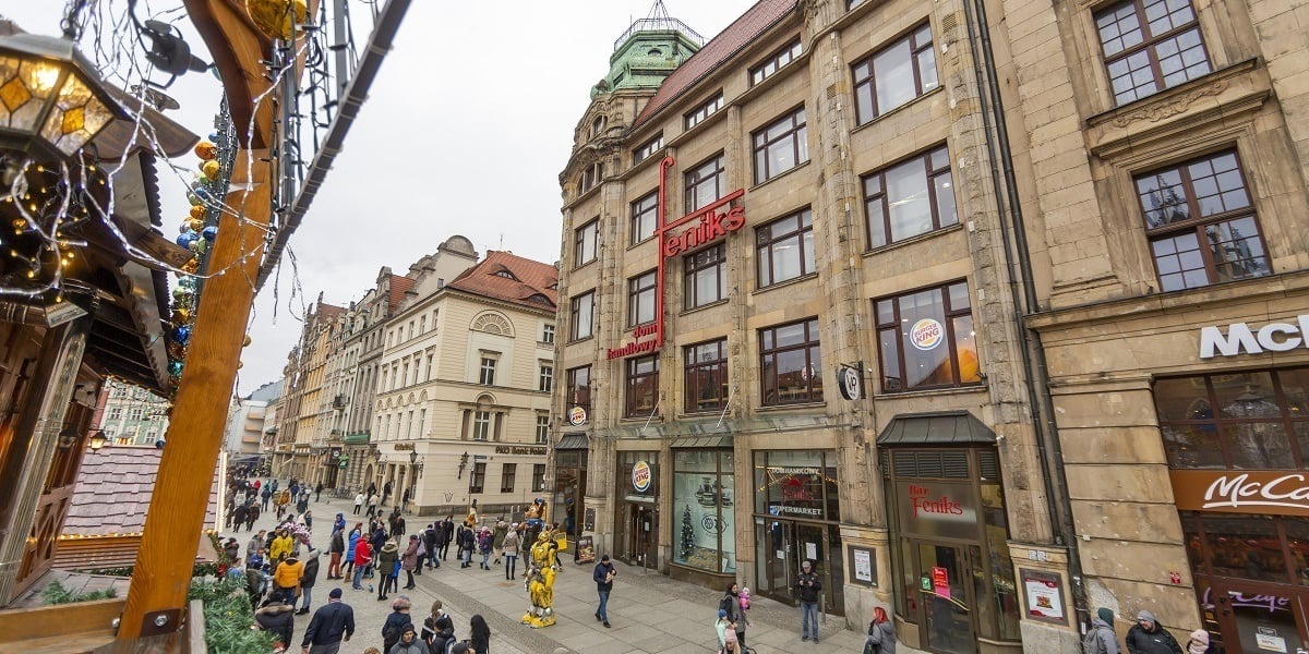 Ludzie na ulicy i gmach domu Handlowego Feniks na Rynku we Wrocławiu 