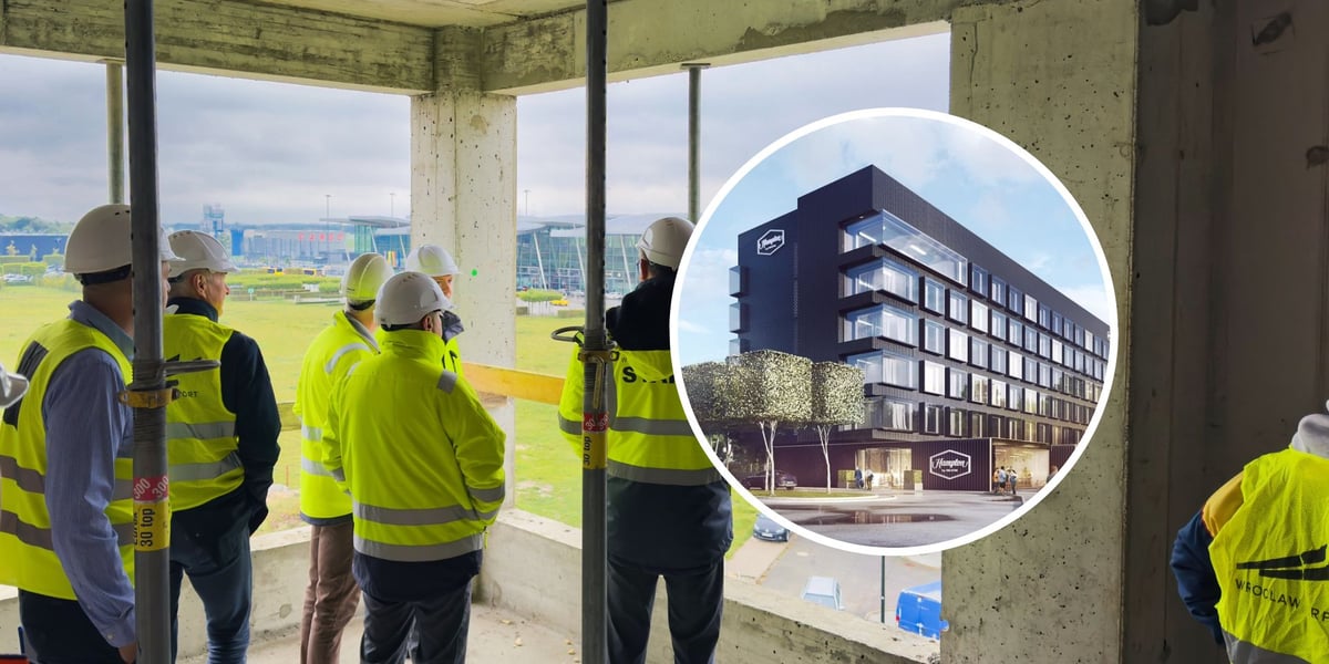Mężczyźni w kamizelkach ochronnych i kaskach na głowie na budowie Hotel Hampton by Hilton Wrocław Airport, w kółku wizualizacja hotelu