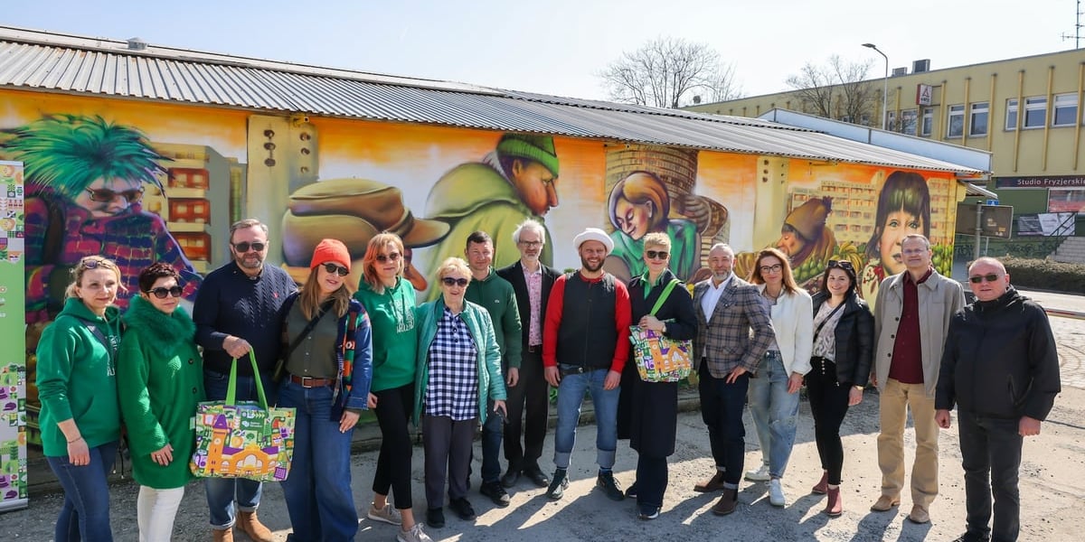 Uczestnicy odsłonięcia muralu na targowisku "Komandor".