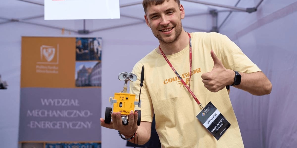 Mężczyzna trzyma w rękach małego robota (Smart City Day 2025 na placu Solnym)