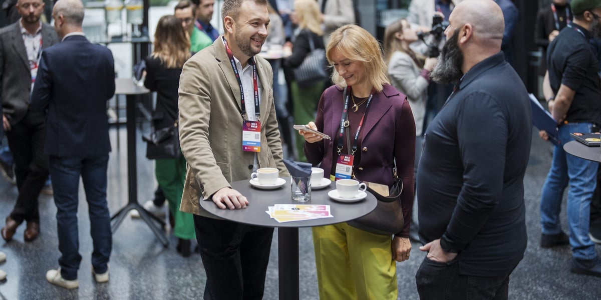 Ludzie przy stolikach rozmawiający w ramach networkingu
