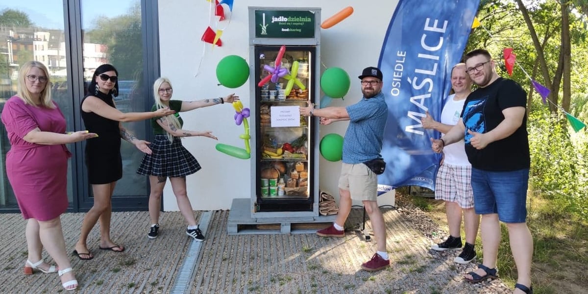 Jadłodzielnia na Maślicach została uruchomiona pod koniec lipca tego roku. Niestety stara lodówka (na zdjęciu) szybko się popsuła. Jednak mieszkańcy Maślic kupili nową. Na zdjęciu widać mieszkańców Maślic w czasie otwarcia Jadłodzielni