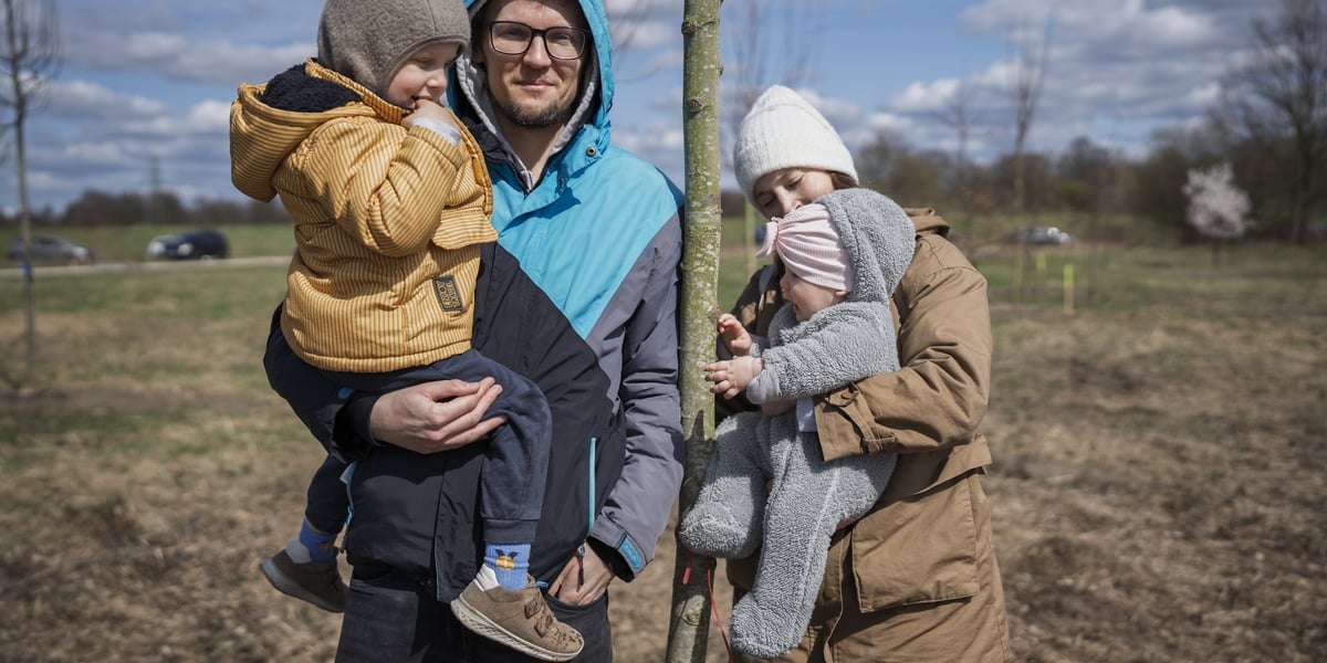 Piknik #WROśnijweWROcław przy ul. Lechitów. Na zdjęciu dwoje uśmiechniętych dorosłych i dwoje dzieci przy młodym drzewku