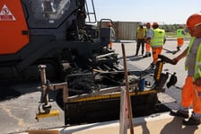 Robotnicy pracujący na wiadukcie, układają ostatnią warstwę nawierzchni