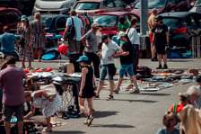Plac przed CH Borek na którym widać ludzi i rozstawione stoiska z rzeczami wystawionymi na sprzedaż lub wymianę podczas Wrocławskiej Wymiany Garażowej