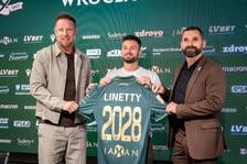 Rafał Grodzicki, Karol Linetty i Remigiusz Jezierski trzymają koszulkęŚląska Wrocław z nazwiskiem piłkarza.