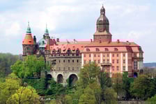 <h3>Zamek Książ</h3>
<p>Zamek Książ znajduje się w Wałbrzychu. Należy do największych zamk&oacute;w w Polsce i zachwyca swoim położeniem. Zamek można zwiedzać z przewodnikiem zar&oacute;wno w dzień, jak i w nocy. Warto zobaczyć także tarasy z pięknymi ogrodami, kt&oacute;re utrzymane są w stylu francuskim - czynne od kwietnia do września. Na terenie kompleksu jest hotel z wykwintną restauracją.</p>
<ul>
<li>Adres: Piast&oacute;w Śląskich 1, Wałbrzych</li>
</ul>