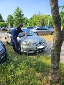 Źle zaparkowane samochody. Strażnik miejski zostawia informację o mandacie