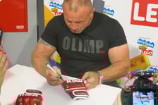 <p>Mariusz Pudzianowski podpisuje swoje rękawice</p>