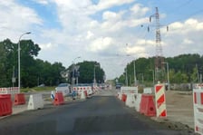 Na ul. Kosmonautów trwają prace budowlane, robotnicy układają masę bitumiczną.