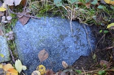 fragment płyty nagrobnej wmurowanej w ocembrowanie stawu