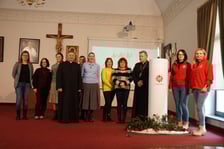 <p>Wolontariusze wraz abp. J&oacute;zefem Kupnym obok jubileuszowej świecy wigilijnej</p>