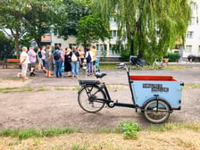 Uczestnicy oraz prowadzący podczas spotkań konsultacyjnych na podwórkach. Widoczny jest też, specjalnie oznaczony rower cargo będący mobilnym punktem konsultacji.