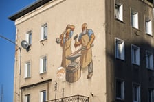 <p>Mozaika na elewacji domu nr 11 przy ul. Ustronie pokazuje dw&oacute;ch kowali przy pracy</p>