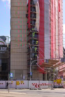 <p>Budynek Arkad Wrocławskich zasłonięty rusztowaniem - pracownicy na rusztowaniu</p>
