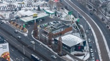 Widok na działkę z budynkami przeznaczonymi do rozbiórki: stacją paliw, restauracją i pawilonem (luty 2026)