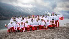<p>Grupa sportowc&oacute;w w białych bluzach i czerwonych spodniach na tle ośnieżonych g&oacute;r - kadra Polski w pływaniu lodowym, Molveno 2026</p>