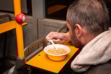 <p>Mężczyzna jedzący zupę w Streetbusie</p>