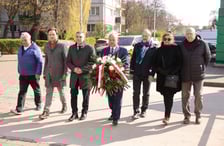 <p>Składanie kwiat&oacute;w pod tablicą Jerzego Szmajdzińskiego</p>