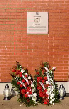 <p>Składanie kwiat&oacute;w pod tablicą Jerzego Szmajdzińskiego</p>