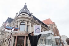 <p>Malwa Domaradzka z plakatem, na kt&oacute;rym przedstawiła Hotel Monopol na tle prawdziwego budynku</p>