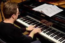 <p>Piotr Alexewicz podczas pr&oacute;by w sali czerwonej Narodowego Forum Muzyki</p>