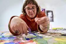<p>Olga Budzan przy zszywaniu tkaniny artystycznej w Barbarze</p>