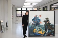 <p>Modesta Gorol przy swoim obrazie podczas przygotowań do wystawy w CK Agora</p>