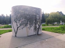 Toaleta w parku Jedności z jasną mozaiką, na której widzimy ciemne kontury drzew