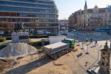 Wykopki pod rośliny przy konnym pomniku Bolesława Chrobrego, na tle Renomy