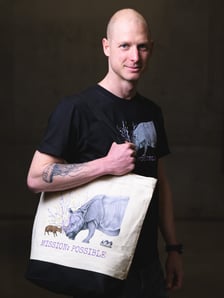 Marcin Borowski, opiekun zwierząt kopytnych w ZOO Wrocław prezentuje produkty z grafiką Macieja Matuszaka, opiekuna małp, przedstawiającą mundżaka chińskiego Tatę i samicę nosorożca indyjskiego Marusię