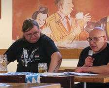 <p>Przemysław Wojcieszek podczas spotkania autorskiego, obok Jacek Zawadzki czyta fragmenty powieści &bdquo;Świnie wojny&rdquo;</p>