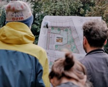 Przykład spotkania konsultacyjnego na podwórku. W tle wywieszona koncepcja zagospodarowania podwórka.