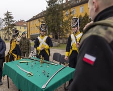 <p>Na placu apelowym stały stoiska pokazowe. Na jednym z nich podchorążowie ubrani w stroje z epoki napoleońskiej prezentowali broń historyczną&nbsp;</p>