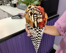 Ice rolls & Twojaczekoladka, znajduje się przy ul. Kuźniczej 10. Zamówisz tutaj bubble waffle w sześciu smakach: owocowy, oreo, nutella, kinder bueno (na zdjęciu), raffaello i masło orzechowe. Cena: 17 zł, a z dodatkową gałką lodów - 19 zł. Godziny otwarcia: od poniedziałku do soboty, w godz. od 10:00 do 22:00, w niedziele od 10:00 do 21:00.