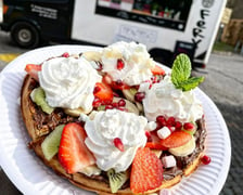 Tentego pizza & gofery działa eventowo. Ich foodtrucki mogliśmy zobaczyć m.in. pod Halą Stulecia i na wielu beach barach. W ofercie są wyboru gofry na słodko, np. z mascarpone, owocami i sosem mango lub na słono ? z hummusem, czarnuszką, ogórkiem, pomidorkami, rukolą i pestkami słonecznika. Można go schrupać razem ze znajomymi, ponieważ jest okrągły i podzielony na cztery kawałki. W ten weekend (26-28 sierpnia) zjemy okrągłe gofry na wydarzeniu Winiarze i Gastro Miasto (Tor Wyścigów Konnych Partynice), a także w Zamku Leśnica na Dniach Fantastyki. Szczegóły postoju trucka znajdziemy na facebooku. Cena: od 9 do 30 zł.