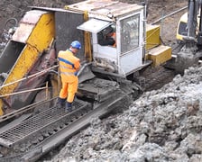 Wał przeciwpowodziowy przy ul. Ślęzoujście w czasie przebudowy przy użyciu maszyny nazywanej trencher