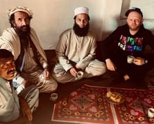 Na zdjęciu Andrzej Gliniak siedzi na dywanie i pije herbatę w towarzystwie Pakistańczyków w Peszawarze, jednym z najniebezpieczniejszych miast Pakistanu, tuż przy granicy z Afganistanem. Siedzący najbliżej mężczyzna ma ksywkę ?Talib?.
