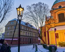 Na zdjęciu widać mężczyznę, który zapala latarnię na Ostrowie Tumskim we Wrocławiu