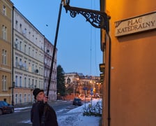 Na zdjęciu widać mężczyznę, który zapala latarnię na Ostrowie Tumskim we Wrocławiu