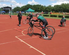 <p>Pokaz frame runningu, dyscypliny sportowej dla os&oacute;b z niepełnosprawnościami. Mężczyzna biegnie, opierając się na tr&oacute;jkołowym rowerze</p>