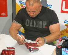 <p>Mariusz Pudzianowski podpisuje swoje rękawice</p>