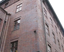 <p>Budynek Komendy Wojew&oacute;dzkiej Policji przy Podwalu. Ściany, pokryte klinkierową cegłą, nie są jednak&nbsp;monotonne, posiadają wyrafinowaną, dyskretną dekorację&nbsp;nadającą im charakter relief&oacute;w.</p>