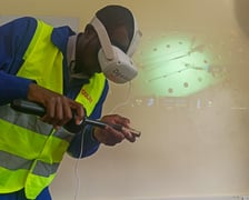 Na zdjęciu mężczyzna w odzieży ochronnej z symulatorem spawania w VR firmy Dig In Vision na wystawie EXPO 2022