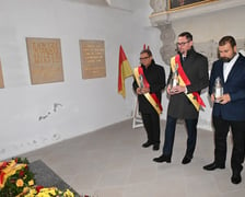 <p>Radni Wrocławia z przewodniczącym Sergiuszem Kmiecikiem (w środku) składają znicze w kaplicy rajc&oacute;w</p>