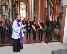 <p>Radni Wrocławia z przewodniczącym Sergiuszem Kmiecikiem (z prawej) składają znicze w kaplicy rajc&oacute;w. Święci ks. porucznik Tomasz Miencicki</p>