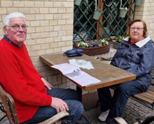 <p>Ogr&oacute;dki gastronomiczne na Starym Mieście we Wrocławiu w marcu 2024</p> Na zdjęciu dwie osoby: pan w czerwonym swetrze siedzi przy stoliku z panią