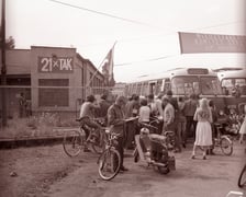 Na zdjęciu brama wjazdowa do zajezdni autobusowej nr VII, dwa autobusy jelcz 043, transparent „21 x tak” i transparent Międzyzakładowego Komitetu Strajkowego.