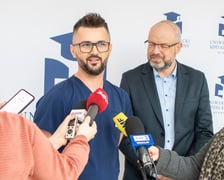 Na zdjęciu dwóch męzczyzn, jeden w lekarskim uniformie. Od lewej: Andrzej Mędrala, ratownik i pielęgniarz koordynujący w SOR USK we Wrocławiu i lek. Maciej Kamiński, wicedyrektor ds. medycznych USK we Wrocławiu
