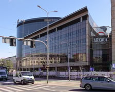<p>Budynek Arkad Wrocławskich za budowlanym ogrodzeniem</p>